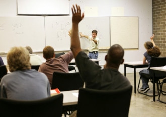 Adult education teacher in front of his class.